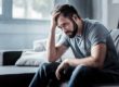 man sitting on bed dealing with mental health and substance abuse laws