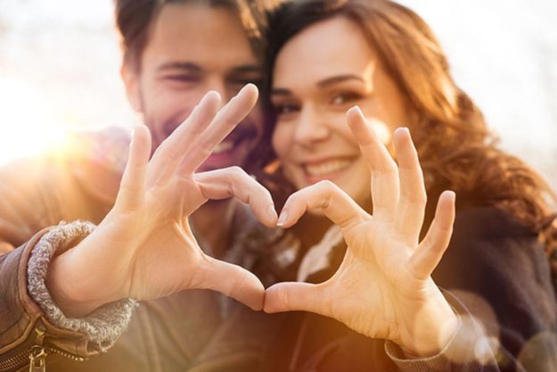 couple making heart hands having a sober valentines day