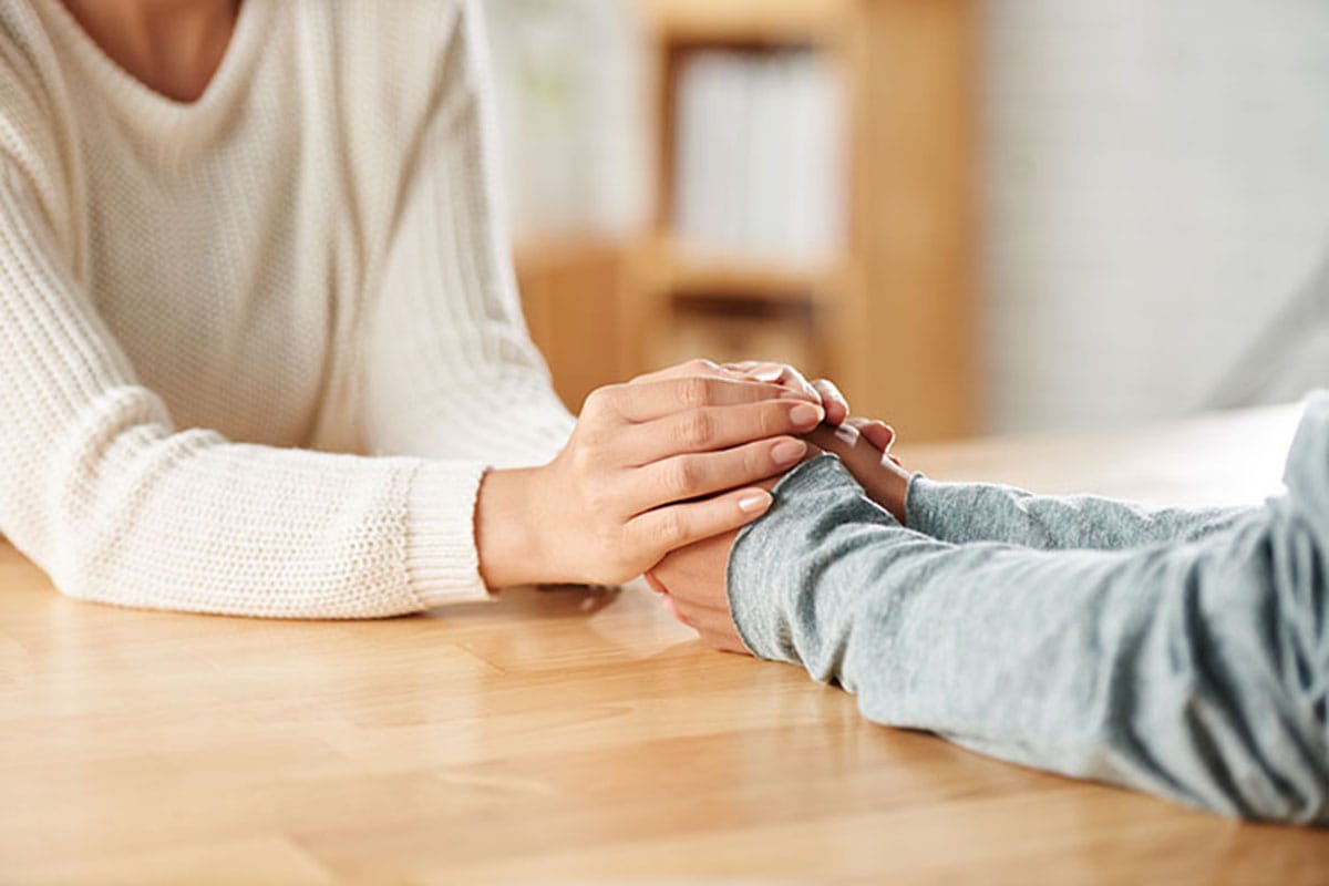 couple holding hands across table learning about addiction recovery tools