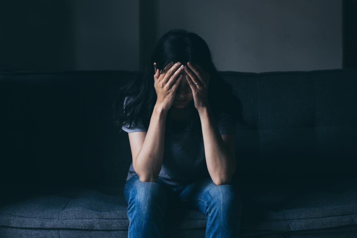 A woman sits on the couch as she considers cocaine addiction treatment in florida before calling a cocaine addiction rehab program in tampa