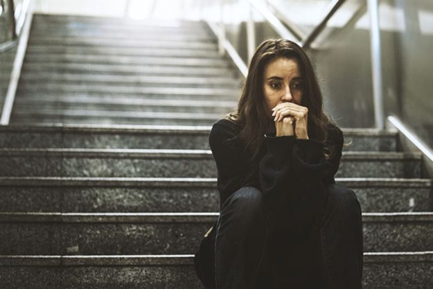 person sitting on stairs anxious about naloxone